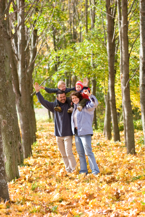 Family walking in autumn leaves